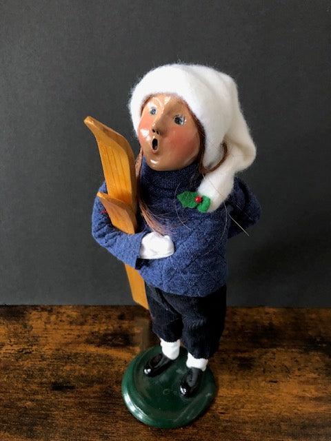 Girl in Blue with white hat and wooden skiis