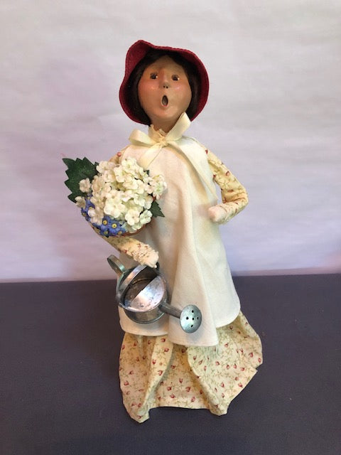 Gardening Lady in yellow with flowers and watering can