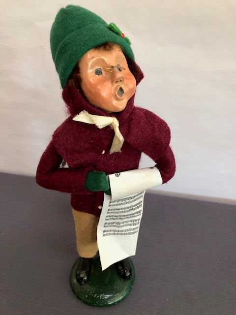 Boy in burgundy and tan with green hat & music sheet