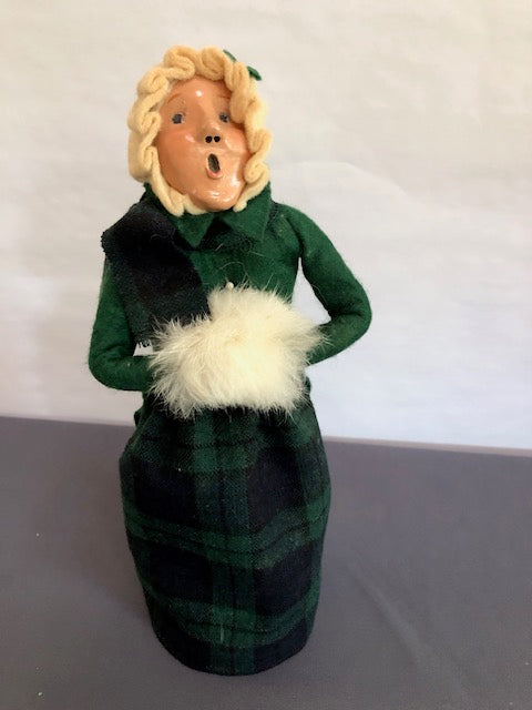 Woman in green & navy plaid with cream fur muff