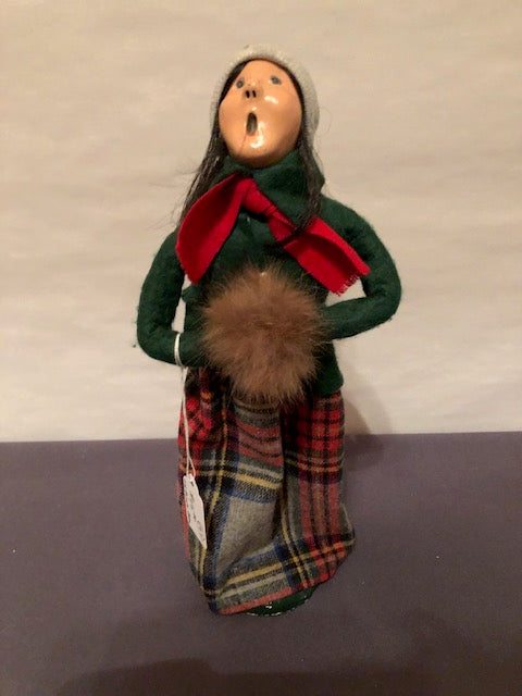 Woman in green and grey plaid skirt with brown fur muff