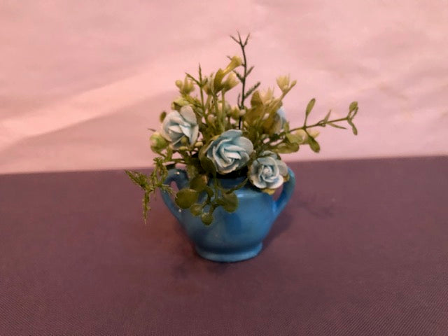 Blue roses in blue handled vase