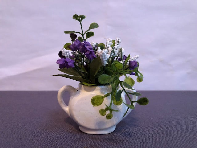 Purple flowers in white two handled vase