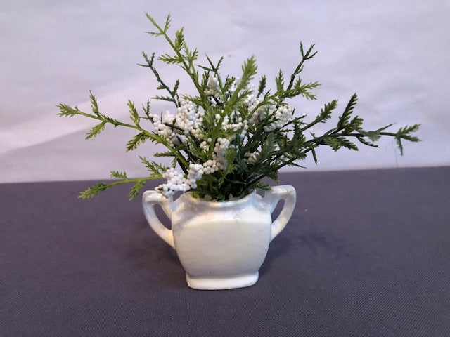 White flowers in white double handled vase