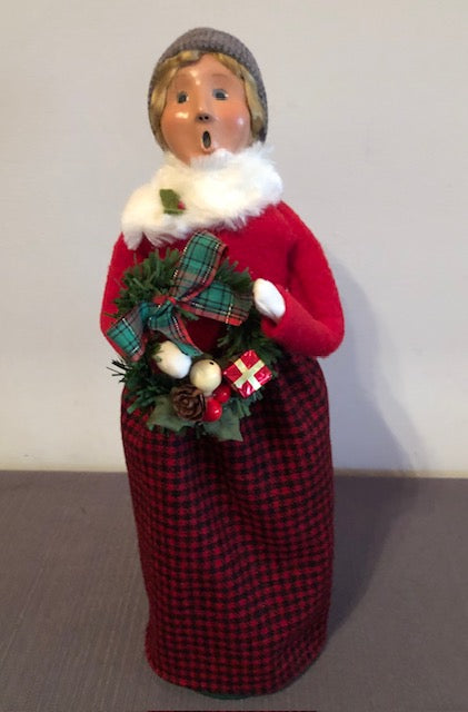 Woman in red with black checkered skirt with wreath