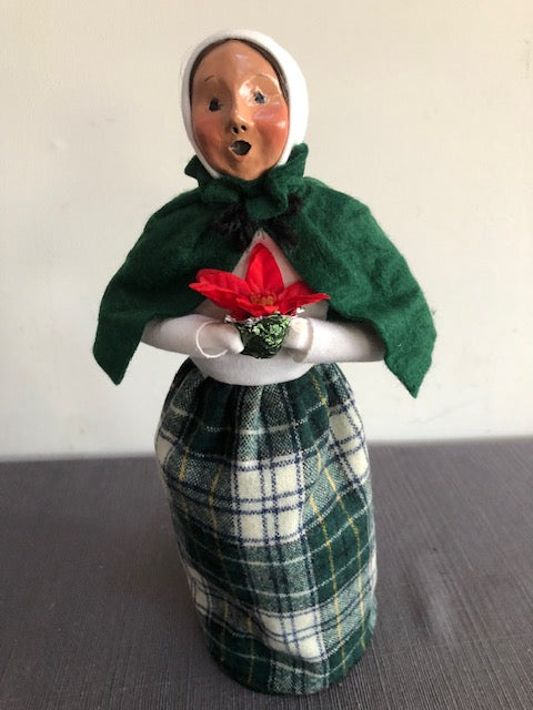 Woman in white and green plaid with poinsettia flower